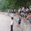 Rất đông người hiếu kỳ đã tập trung quanh khu vực hồ Giảng Võ (Ảnh: Sơn Bách/Vietnam+)
