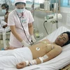 Cán bộ y tế kiểm tra sức khỏe bệnh nhân sốt xuất huyết đang được điều trị tại Bệnh viện Bệnh nhiệt đới, Thành phố Hồ Chí Minh. (Ảnh: Dương Ngọc/TTXVN)