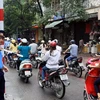 Thanh tra giao thông hướng dẫn người dân đi đúng làn đường trên tuyến phố Huế-Hàng Bài, Hà Nội. (Ảnh: Thế Duyệt/TTXVN)