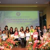 Bà Phan Thị Ý Nhi và đại diện Ban chấp hành Hội khen thưởng các cháu có thành tích xuất sắc trong học tập và thể thao. (Ảnh: Văn Long/Vietnam+)
