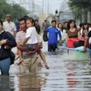 Người dân đi lại tại khu vực ngập lụt ở tỉnh Pathum Thani, ngoại ô Bangkok, ngày 18/10. (Ảnh: AFP/TTXVN)