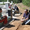Ông Andre Menras phỏng vấn vợ một ngư dân mất tích, trước ngôi mộ gió ở Bình Châu (Quảng Ngãi). (Nguồn: truongsahoangsa.info)