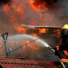 Nhân viên cứu hỏa nỗ lực khống chế đám cháy. (Ảnh: AFP/TTXVN)