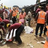 Nhân viên cứu hộ di chuyển thi thể các nạn nhân vừa tìm thấy tại hiện trường vụ tai nạn ngày 29/5. (Ảnh: AFP/TTXVN)