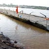 Một phần cầu phao sau khi bị trôi dạt về hạ lưu đã được kéo vào bờ. (Ảnh: Bách-Hùng/Vietnam+)
