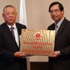 Đại sứ Nguyễn Phú Bình trao tấm biển đồng lãnh sự danh dự cho ông Nakajima. (Ảnh: Phóng viên TTXVN ở Tokyo) 