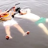 Hai cha con ông Bạch vừa biểu diễn khả năng tự nổi trên mặt nước, vừa đờn ca vọng cổ. (Ảnh: Internet)