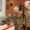 Các cựu binh Việt Nam đang tìm hiểu những hiện vật được trưng bày trong triển lãm. (Ảnh: Anh Tuấn/TTXVN)