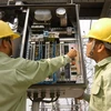Công nhân Công ty truyền tải điện 4 bảo dưỡng thiết bị trạm biến áp Long Bình (Đồng Nai). (Ảnh: Ngọc Hà/TTXVN)