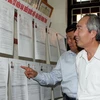 Phó Chủ tịch Hội đồng bầu cử Trung ương kiểm tra danh sách cử tri tại nơi niêm yết - phường Ninh Xá, thành phố Bắc Ninh. (Ảnh: Nguyễn Dân/TTXVN)