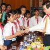 Chủ tịch nước Nguyễn Minh Triết tặng quà cho các cháu. (Ảnh: Nguyễn Khang/TTXVN)