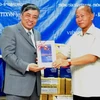 TGĐ Trần Mai Hưởng trao tặng sách cho TGĐ Thông tấn xã KPL Khamsen Phongsa. (Ảnh: Hoàng Chương/TTXVN)