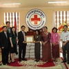 Đại diện Ngân hàng Đầu tư và Phát triển VN trao tặng đồ cứu trợ tại Hội Chữ Thập Đỏ Campuchia. (Ảnh: Trần Long/Vietnam+)