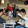 Người lao đông nộp hồ sơ đăng ký dự thi tiếng Hàn tại Trung tâm Giới thiệu việc làm Hà Nội. (Ảnh: Hữu Việt/TTXVN)