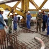 Công nhân thi công mẻ bê tông cuối cùng của cầu Bạch Hổ. (Ảnh: Quốc Việt/Vietnam+)