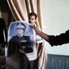 NTC tịch thu một bức ảnh của cựu lãnh đạo Libya Gaddafi trong căn hộ của một người bị nghi ngờ là phần tử trung thành bất ổn tại Abu Salim. (Ảnh: AFP)