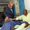Tổng thống Jacob Zuma (trái) tới thăm một thợ mỏ bị thương trong vụ xung đột ở mỏ Marikana. (Ảnh: AFP/TTXVN)