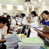 Khách hàng giao dịch tại bộ phận kế toán kiểm soát chi của Kho bạc Nhà nước Hà Nội. (Ảnh: Minh Tú/TTXVN)