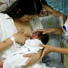 Nhân viên y tế Bệnh viện Phụ sản TW hướng dẫn sản phụ cho trẻ bú mẹ ngay giờ đầu sau khi sinh. (Ảnh: Dương Ngọc/TTXVN)