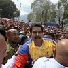 Tổng thống Nicolas Maduro (giữa) và những người ủng hộ tại Caracas ngày 16/4. (Ảnh: AFP/TTXVN)