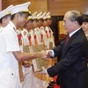 Chủ tịch Quốc hội Nguyễn Sinh Hùng tặng quà cho các thanh niên công an tiêu biểu. (Ảnh: Nhan Sáng/TTXVN)