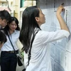 Các thí sinh xem số báo danh tại Hội đồng thi Trường THPT Việt Đức (Hà Nội). (Ảnh: Quý Trung/TTXVN)