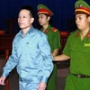 Cảnh sát dẫn giải bị cáo Đoàn Văn Vươn vào phòng xử án. Ảnh: Doãn Tấn - TTXVN
