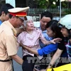 Thanh niên tình nguyện và cảnh sát giúp người già vào viếng Đại tướng Võ Nguyên Giáp. (Ảnh: Doãn Tấn/TTXVN)