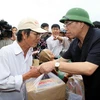 Tổng Bí thư thăm và trao đồ cứu trợ các gia đình chính sách xã Phước Thuận, huyện Tuy Phước, Bình Định. (Ảnh: Đinh Xuân Tuân/TTXVN) 