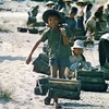 Trẻ em dọn dẹp vỏ đạn trên quốc lộ 1, tháng 7 năm 1975. (Ảnh: Isicaoa Bundo)