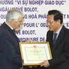 Thứ trưởng Bộ Giáo dục và Đào tạo Phạm Vũ Luận trao kỷ niệm chương cho Đại sứ Pháp tại Việt Nam Hervé Bolot. (Ảnh: Bích Ngọc/ TTXVN) 