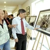 Các đại biểu xem triển lãm "Những khoảnh khắc lịch sử." (Ảnh:Thế Anh/TTXVN) 