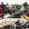 Nhân viên an ninh và cứu trợ làm nhiệm vụ tại khu vực máy bay rơi. (Ảnh: AFP/TTXVN) 