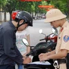 Cảnh sát giao thông thành phố Hà Nội xử phạt người vi phạm luật giao thông. (Ảnh: Thống Nhất/TTXVN) 