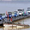 Các phương tiện giao thông đi trên cầu phao qua sông Hồng. (Ảnh: Trọng Đức/TTXVN) 