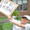Trương Huệ Quyền với tấm biển “Nghỉ việc để xem World Cup” (Nguồn: Chinadaily)