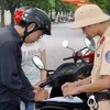 Cảnh sát giao thông thành phố Hà Nội xử phạt người vi phạm luật giao thông. (Ảnh: Thống Nhất/TTXVN)