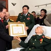Chủ tịch nước Nguyễn Minh Triết trao Bằng chứng nhận Huy hiệu 70 năm tuổi Đảng cho Đại tướng Võ Nguyên Giáp. (Ảnh: Nguyễn Khang/TTXVN)