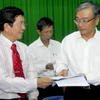 Ông Yang Kun Hsiang,Tổng Giám đốc Công ty Vedan (phải) trao văn bản ký thỏa thuận bồi thường thiệt hại cho nông dân. (Ảnh: Hoàng Hải/TTXVN)