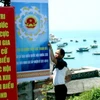 Trang trí panô, khẩu hiệu tuyên truyền về cuộc bầu cử Quốc hội khóa XIII và Hội đồng Nhân dân các cấp ở Cù Lao Chàm. (Ảnh: Nguyễn Sơn/Vietnam+)