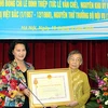 Bộ Trưởng Bộ Lao động-Thương binh và Xã hội Nguyễn Thị Kim Ngân trao tặng Huân chương cho vợ ông Lê Đình Thiệp. (Ảnh: Hữu Việt/TTXVN)