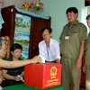 Lực lượng dân phòng hỗ trợ cán bộ tổ bầu cử mang hòm phiếu tới nhà các cử tri không đến được điểm bỏ phiếu vì lý do sức khỏe. (Ảnh: Duy Khương/TTXVN)