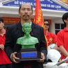 Nghệ sỹ Quang Đạt và tượng Bác Hồ bằng đá non nuớc. (Nguồn: Internet) 