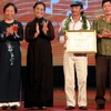 Phó Chủ tịch nước Nguyễn Thị Doan trao giải nhất cho nhạc sĩ Khánh Vinh (áo trắng) với ca khúc "Lời ru". (Ảnh: Nhật Anh/TTXVN)