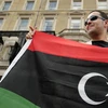 Một người đàn ông cầm cờ phe nổi dậy trước cửa đại sứ quán Libya ở London, Anh. (Nguồn: Getty Images)