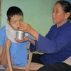 Bà Kiều cho con gái tật nguyền ăn trưa. (Nguồn: vava.org.vn)
