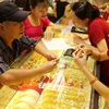 Mua bán vàng tại Công ty Vàng Bảo Tín Minh Châu. (Ảnh: Trần Việt/TTXVN)