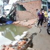Nhà cửa, đường sá ở Xóm Củi, huyện Bình Chánh, Thành phố Hồ Chí Minh bị đổ sập vì sạt lở bờ sông. (Ảnh: Hoàng Hải/TTXVN)