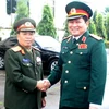 Trung tướng Sengnoun Saynhalat đón Trung tướng Ngô Xuân Lịch. (Ảnh: Hoàng Thanh Chương/Vietnam+)