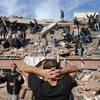 Người dân tìm kiếm cứu nạn người bị mắc kẹt trong một tòa nhà biij đổ sập do động đất làng Tabanli gần Van. (Nguồn: AP) 